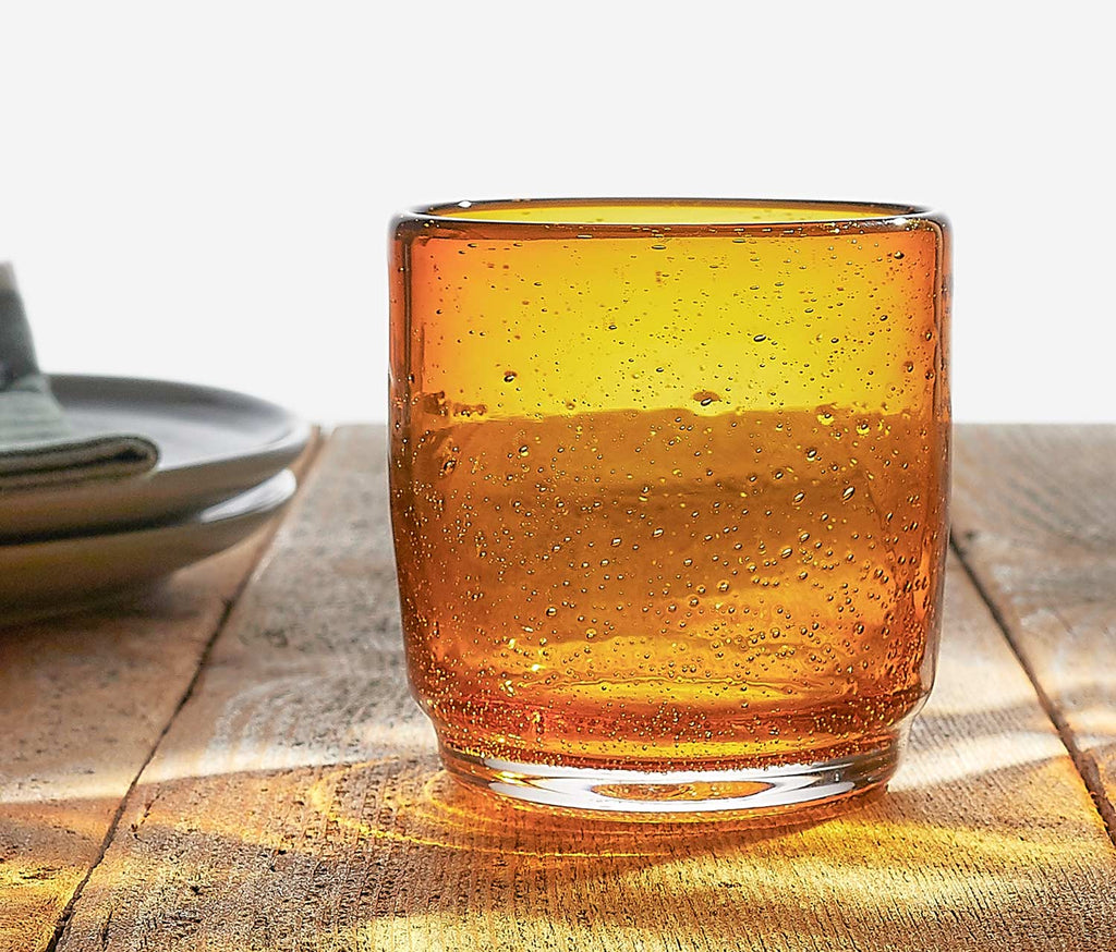Low Amber glass with bubble texture on a wooden table