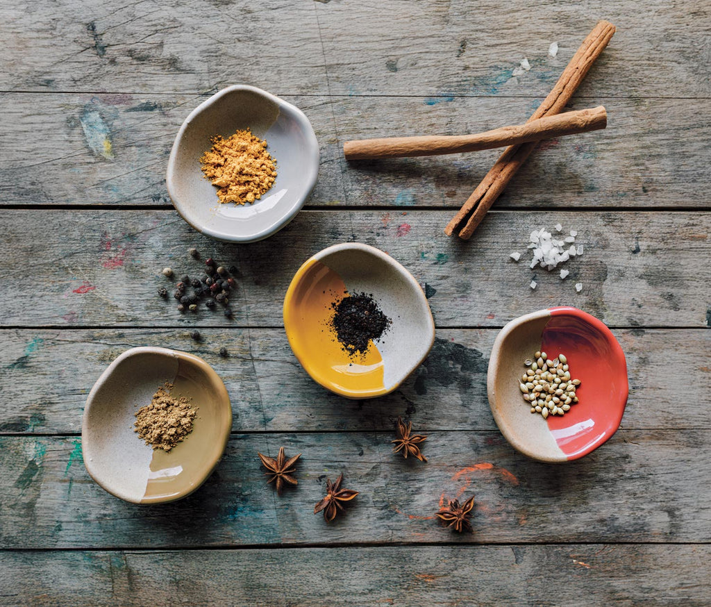 Spices in small pinch pots on a wooden surface - Lollygag