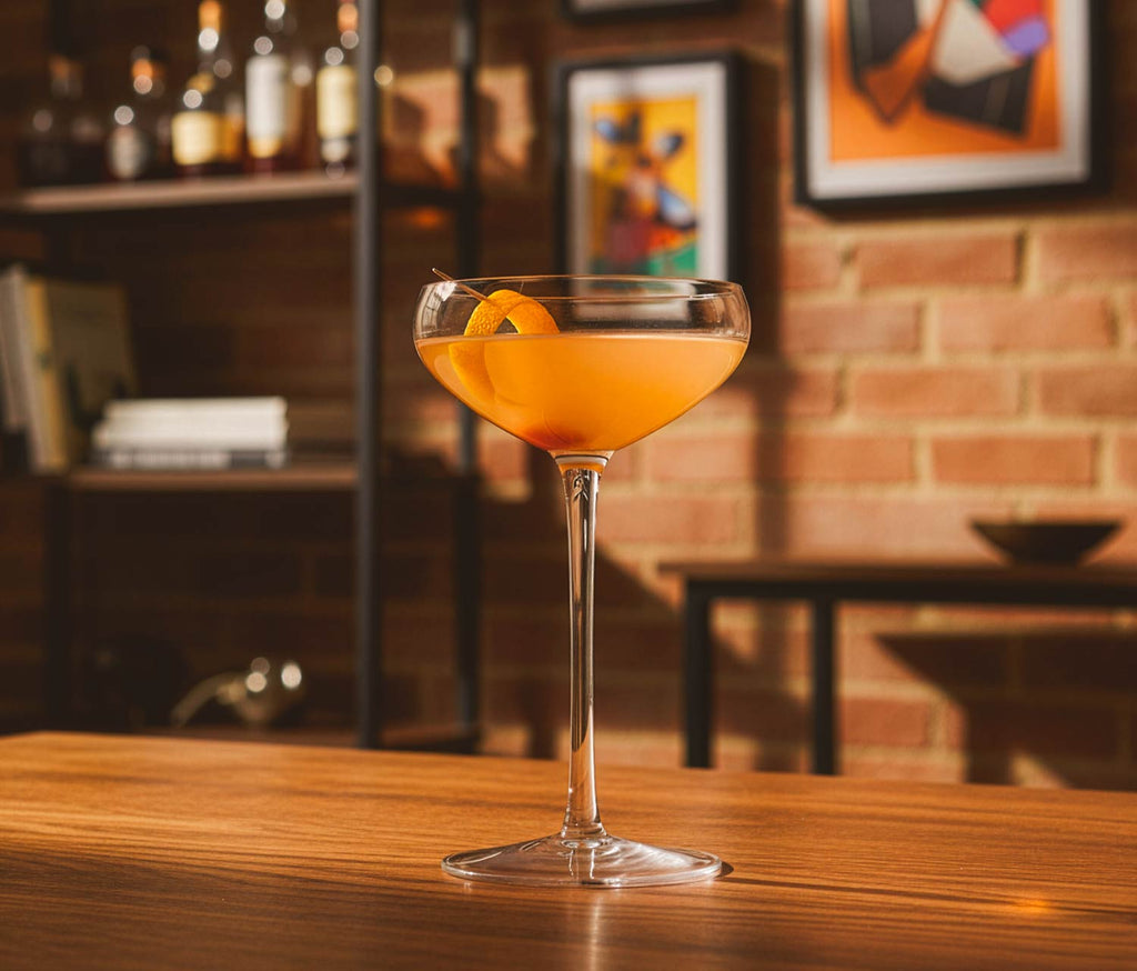 Cocktail in a Crystal glass on a bar with a brick wall - Lollygag