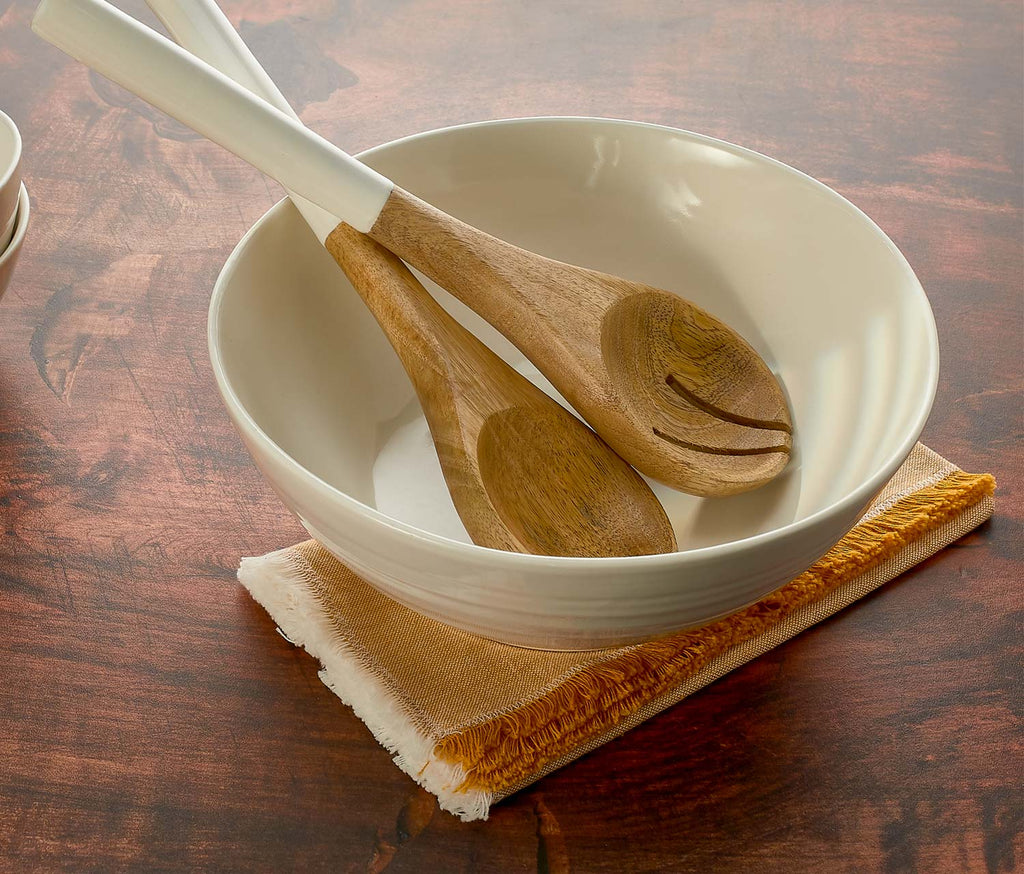 White bowl with wooden spoons on a wooden surface