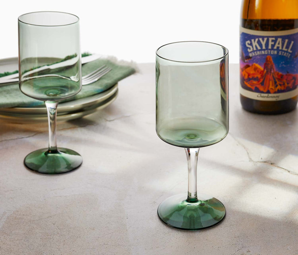 Two green wine glasses on a table with a bottle of 'Skyfall' Washington State wine.