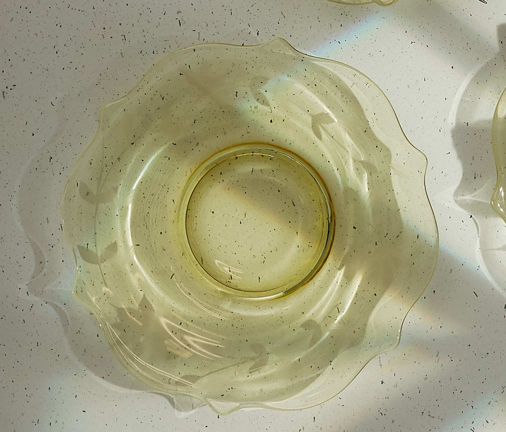 Clear glass bowl with textured surface on a light gray background